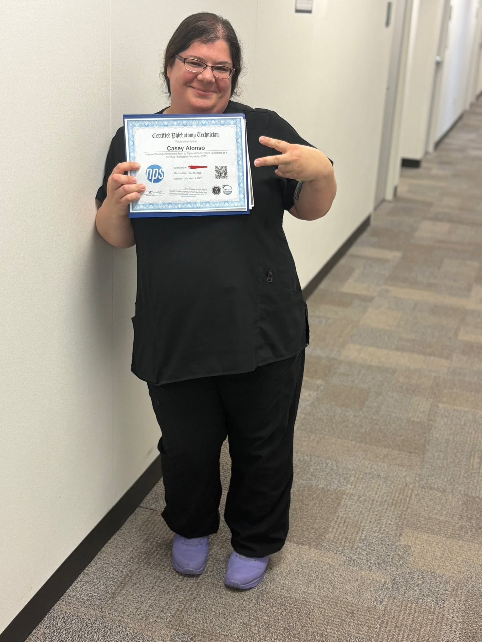 VMI graduate Casey Alonso proudly displaying her Certified Phlebotomy Technician certificate