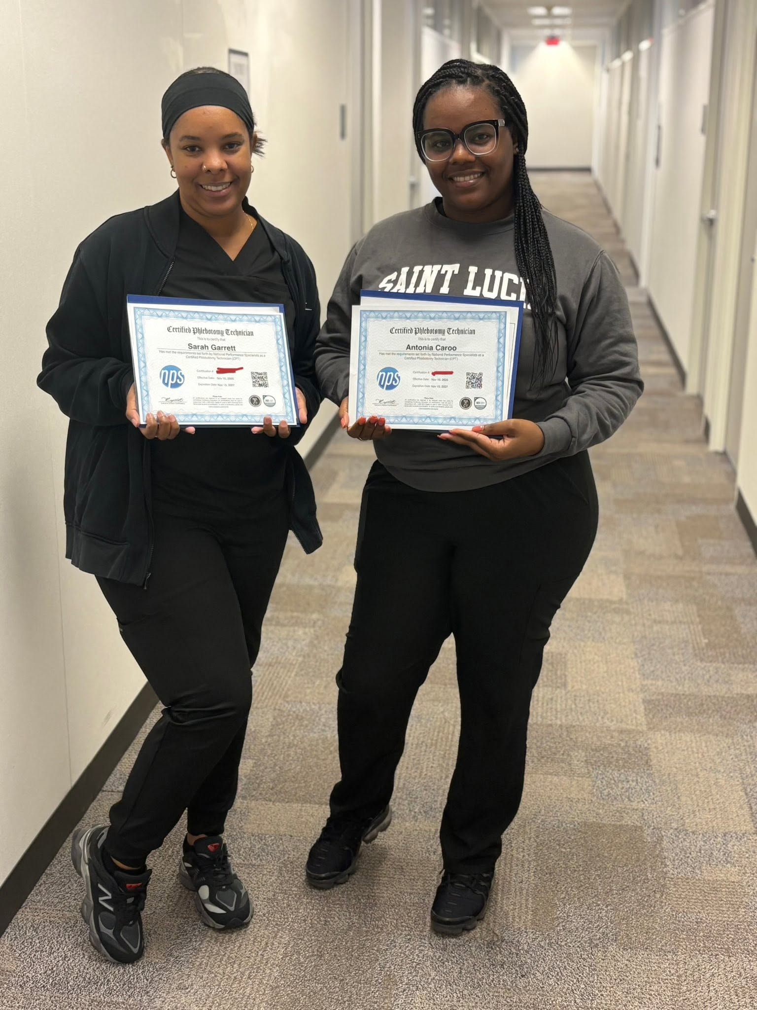VMI graduates Sarah Garrett and Antonia Caroo holding their Certified Phlebotomy Technician certificates